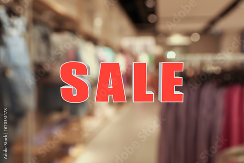 Word Sale and blurred view of fashion store with clothes