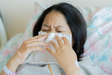 Asian child girl sick with sneezing on the nose and cold cough on tissue paper because weak, teenager sick in hospital, Selective focus, healthcare, and health insurance concept.