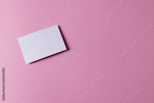 White business card with copy space on pink background