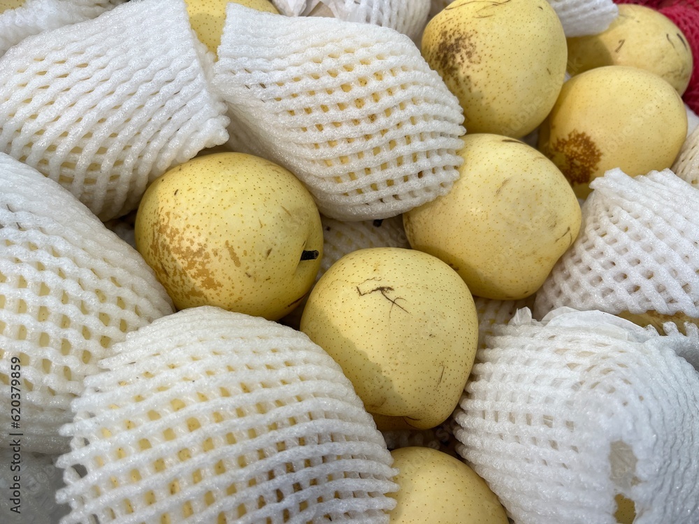 Background image of fresh and ripe pear fruits with foam fruit net in a supermarket for sale Background image of fresh and ripe pear fruits with foam fruit net in a supermarket for sale