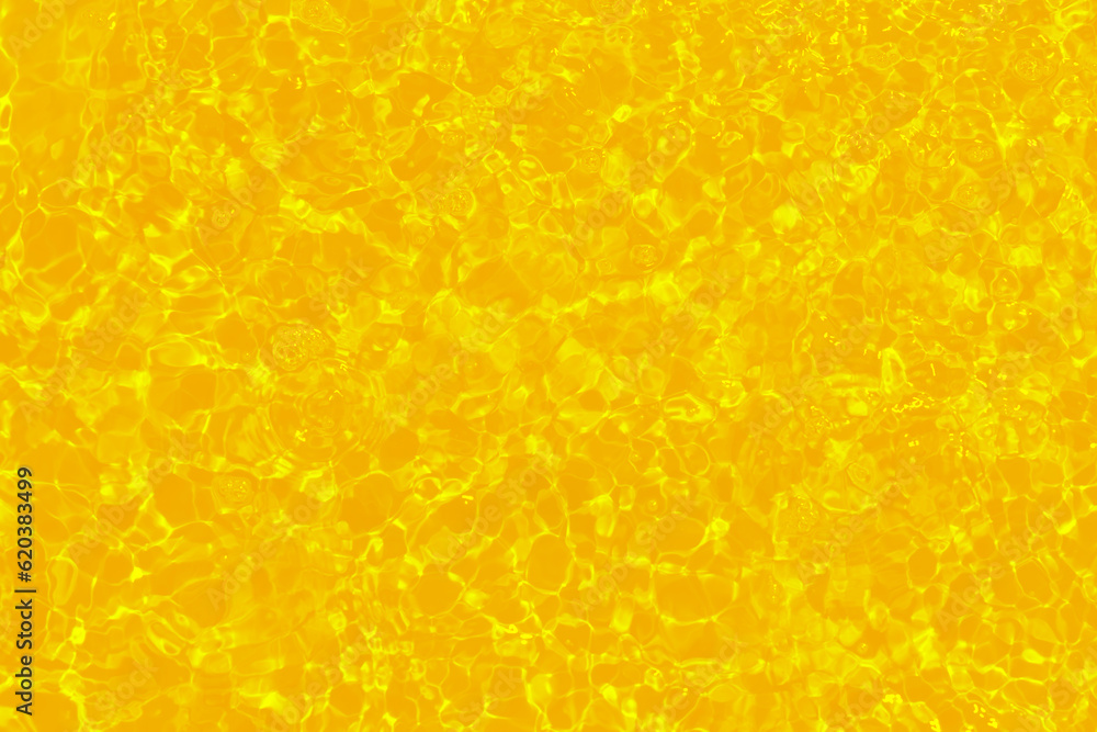 Yellow water with ripples on the surface. Defocus blurred transparent gold colored clear calm water surface texture with splashes and bubbles. Water waves with shining pattern texture background. Yellow water with ripples on the surface. Defocus blurred transparent gold colored clear calm water surface texture with splashes and bubbles. Water waves with shining pattern texture background.