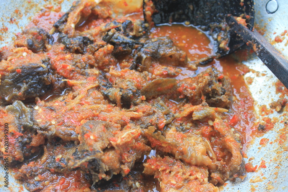 Indonesian dish called Sambal Goreng Lele in an aluminum pan, background blur