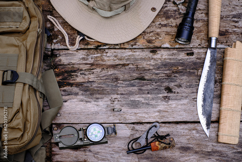 Fotografia Knife backpack with equipment for survival in the forest on the old wooden backg
