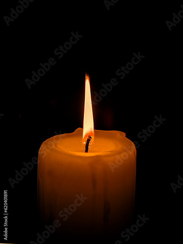 Only light candle burning brightly in the black background