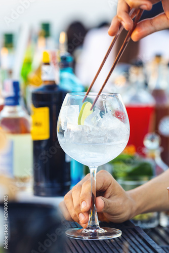 Close-up bartender hand making cocktail at rooftop bar