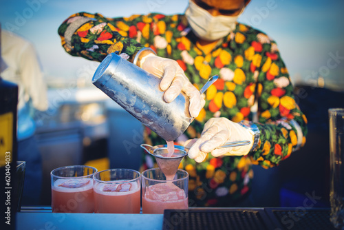 Close-up bartender hand making cocktail at rooftop bar