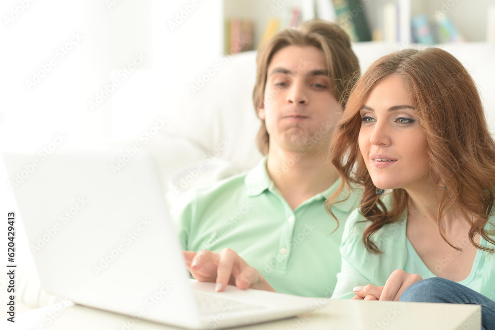Portrait of happy young couple using laptop at home Portrait of happy young couple using laptop at home