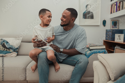 Man with his son on his lap on the sofa photo