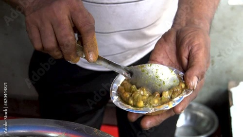 Preparing Indian street food chole kulche. Mixing spices for even taste. photo