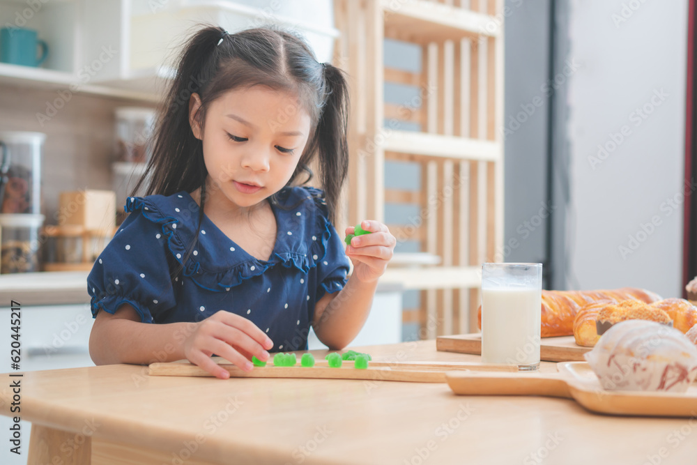 Cheerful little kid girl in the kitchen, Happy Asian child girl having fun in kitchen Cheerful little kid girl in the kitchen, Happy Asian child girl having fun in kitchen