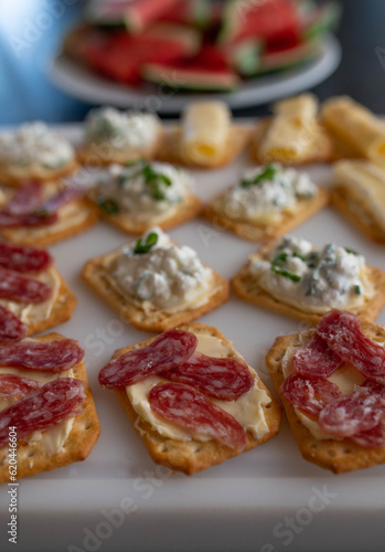 Crackers with salami and cheese on a table