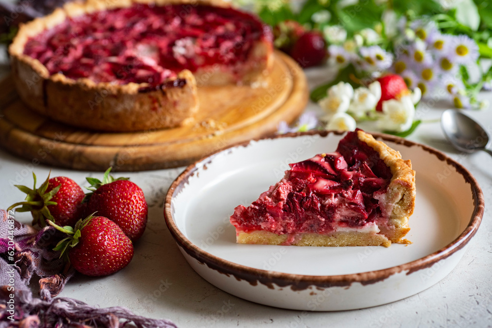 Berry dessert for the whole family: sweet strawberry pie. Strawberry tart on a large plate and a piece of pie on a plate. Strawberry dessert for breakfast. A piece of strawberry pie on a plate. Close Berry dessert for the whole family: sweet strawberry pie. Strawberry tart on a large plate and a piece of pie on a plate. Strawberry dessert for breakfast. A piece of strawberry pie on a plate. Close