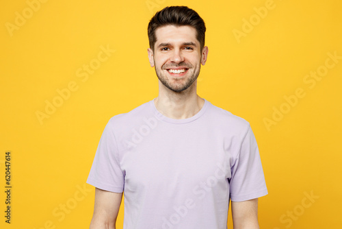 Young smiling happy satisfied cheerful caucasian man wear light purple t-shirt casual clothes looking camera with toothy smile isolated on plain yellow background studio portrait. Lifestyle concept.