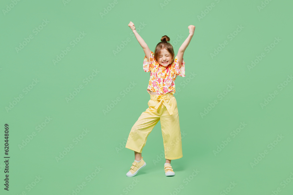 Full body excited little child kid girl 6-7 year old wear casual clothes do winner gesture celebrate clench fists say yes isolated on plain green background Mother's Day love family lifestyle concept Full body excited little child kid girl 6-7 year old wear casual clothes do winner gesture celebrate clench fists say yes isolated on plain green background Mother's Day love family lifestyle concept