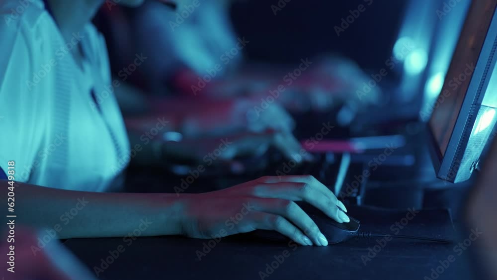 Focused gamers plays a video game, cyber sportsmans play at the international championship, close-up of hands, player uses gaming keyboard, neon light. Focused gamers plays a video game, cyber sportsmans play at the international championship, close-up of hands, player uses gaming keyboard, neon light.