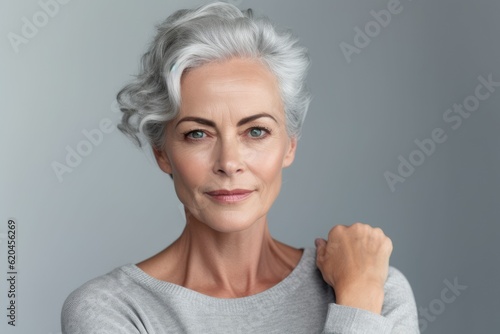 Beautiful gorgeous 50s mid aged mature woman looking at camera isolated on white. Mature old lady close up portrait. Healthy face skin care beauty, middle age skincare cosmetics, cosmetology concept.