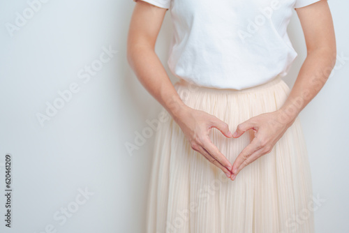 Woman hand heart shape over abdomen. Ovarian and Cervical cancer, Endometriosis, Hysterectomy, Uterine fibroids, Reproductive, menstruation, Stomach, Pregnancy and Sexual Transmitted disease concept photo