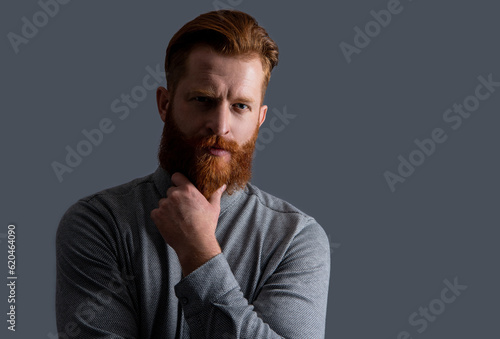 Obraz na plátně Portrait of serious man stroking beard