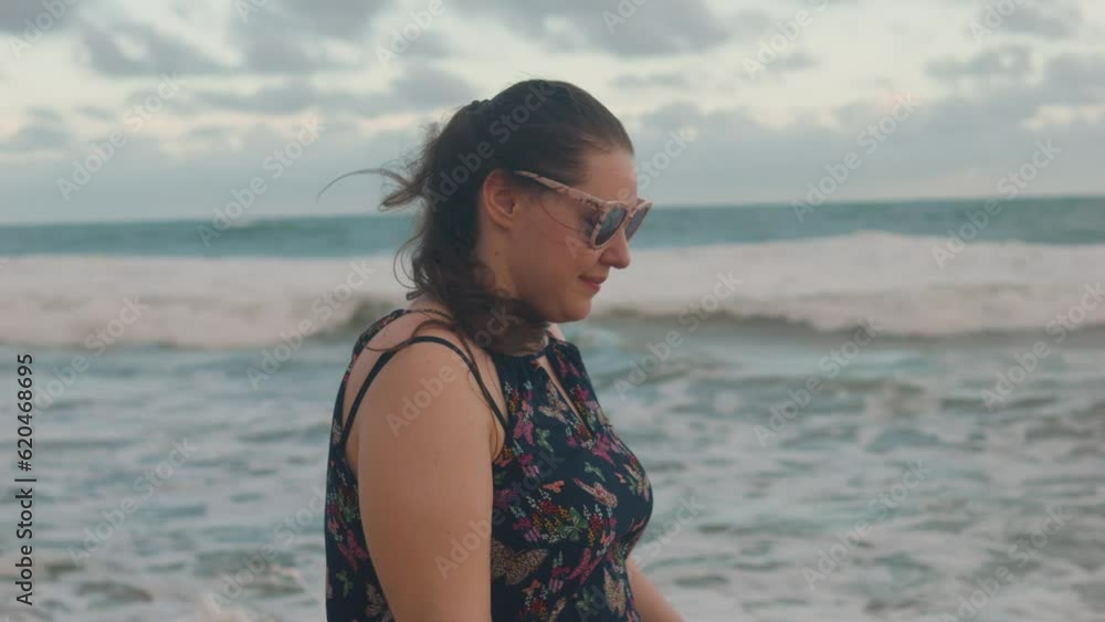 Cute chubby girl in sunglasses walking on a beach. Close up. Cute chubby girl in sunglasses walking on a beach. Close up.