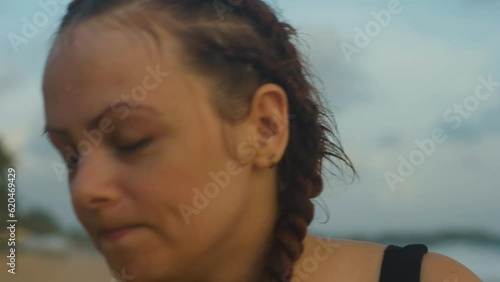 Female boxer MMA fighter looks at camera drinking and spitting bottled water.