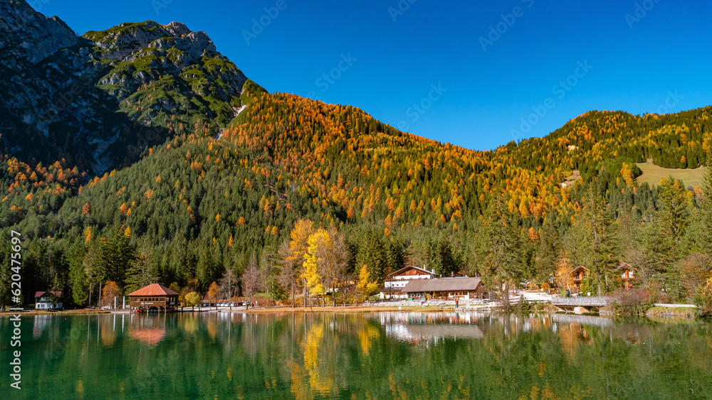 Toblacher Lake Lago di Dobbiaco and Dolomite mountain summits nearby in Autumn October sunset colors, Dolomites, South Tyrol, Italy. Toblacher Lake Lago di Dobbiaco and Dolomite mountain summits nearby in Autumn October sunset colors, Dolomites, South Tyrol, Italy.
