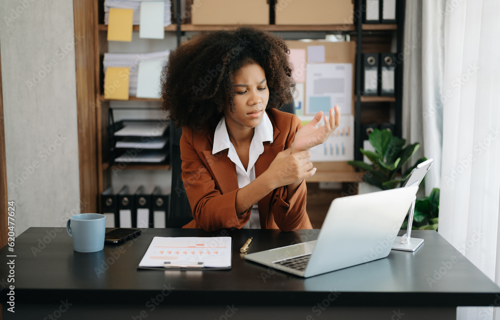 Overworked young African businesswoman office worker suffering from neck pain after had a long day at her office desk. Overworked young African businesswoman office worker suffering from neck pain after had a long day at her office desk.