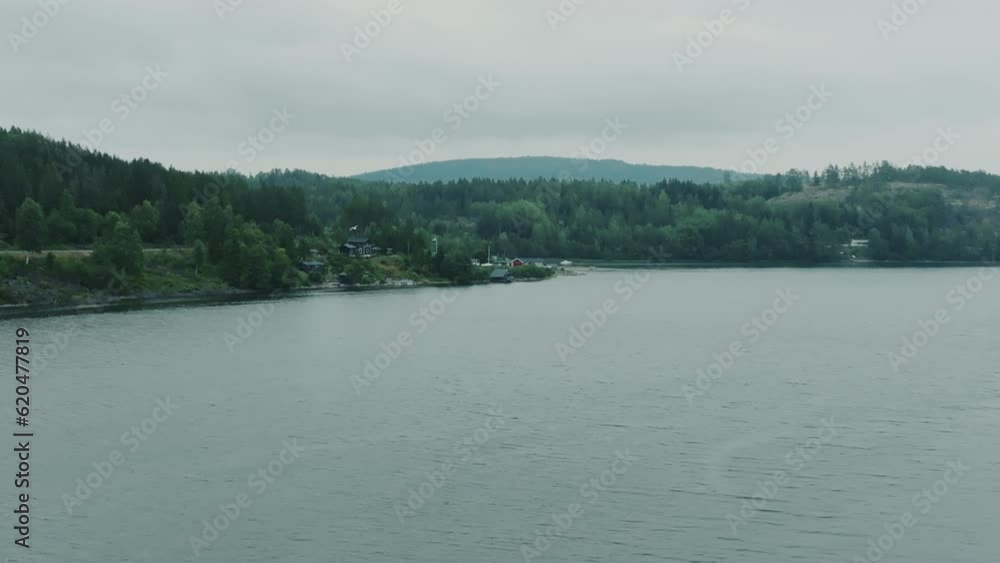Mighty river with beautiful green woods and colorful houses in the background, drone footage Mighty river with beautiful green woods and colorful houses in the background, drone footage