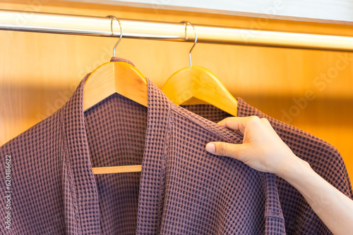 Bathrobe hanging with wooden hangers.