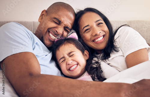 Family, hug and happy on a bed at home with a smile, comfort and security for quality time. Man, woman or latino parents and a girl kid together in the bedroom for morning bonding with love and care