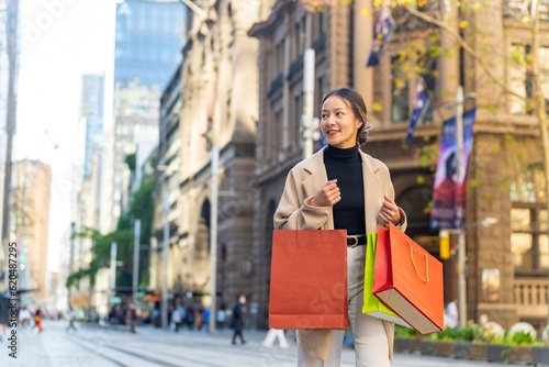 Photography Portrait of Happy Asian woman holding shopping bag walking and shopping in the city together