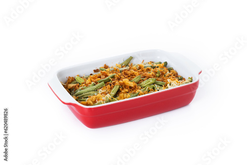 A traditional green bean casserole topped with French Fried Onions and cream of mushroom isolated on white background