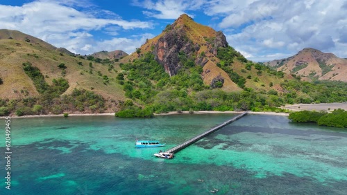 Paradise drone view of Komodo island national park in Indonesia, white luxury yacht in turquoise ocean with coral reefs at a secluded beach, adventure tropical cruise photo