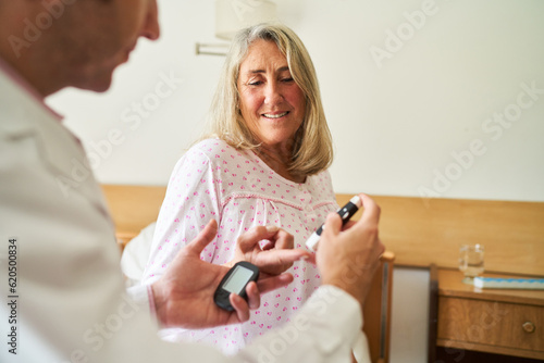 Male nurse checking blood sugar on finger of senior patient