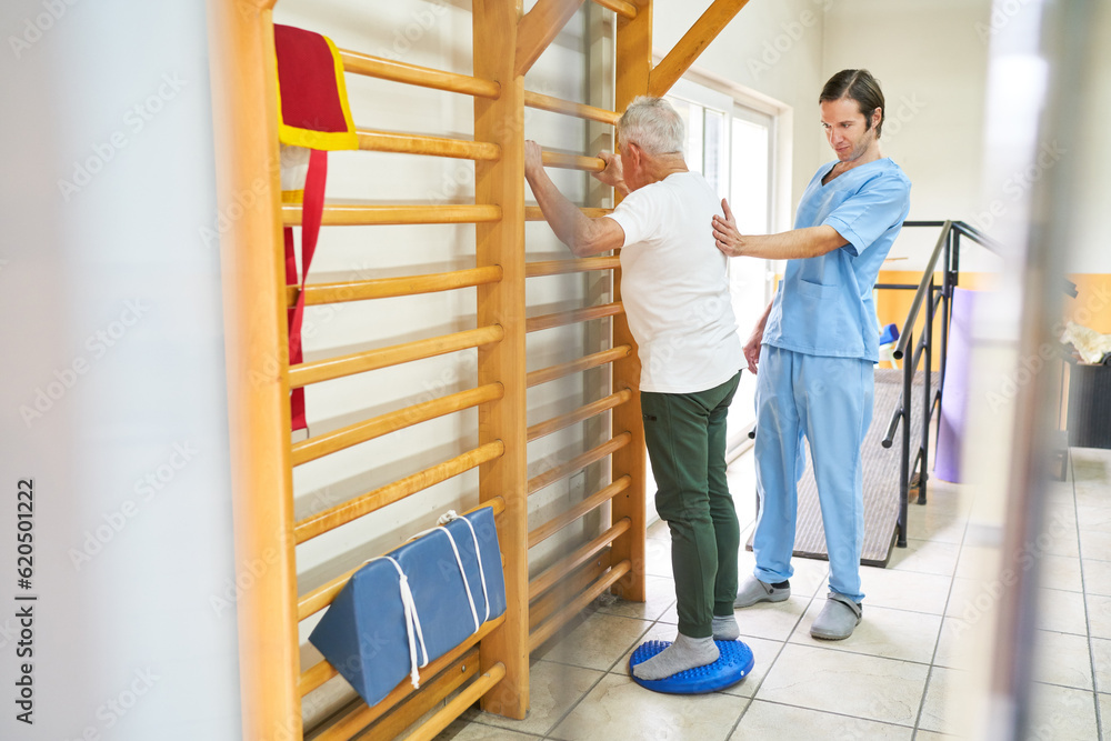 Obraz premium Physiotherapist assisting senior man in exercise at rehab center