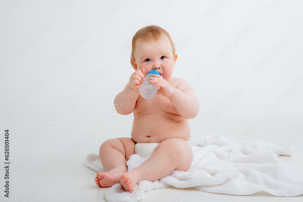 baby in a diaper sitting on a white background drinking from a bottle, high quality photos baby in a diaper sitting on a white background drinking from a bottle, high quality photos