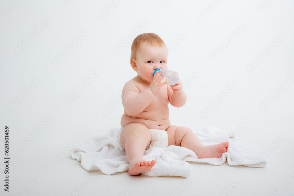 baby in a diaper sitting on a white background drinking from a bottle, high quality photos
