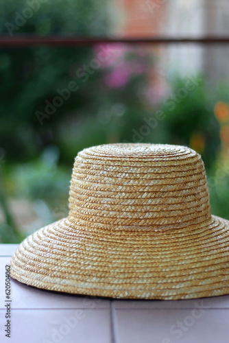 Straw hat hanging in the garden. Selective focus.