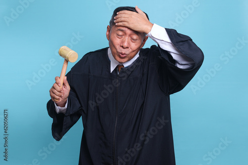 Asian senior judge man has realized something and intending the solution isolated on blue background