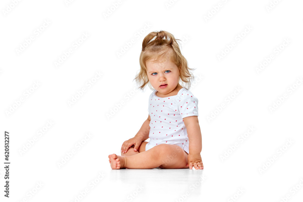 Questioning funny face. Cute, beautiful little girl, toddler sitting on floor with grimacing face against white studio background Questioning funny face. Cute, beautiful little girl, toddler sitting on floor with grimacing face against white studio background