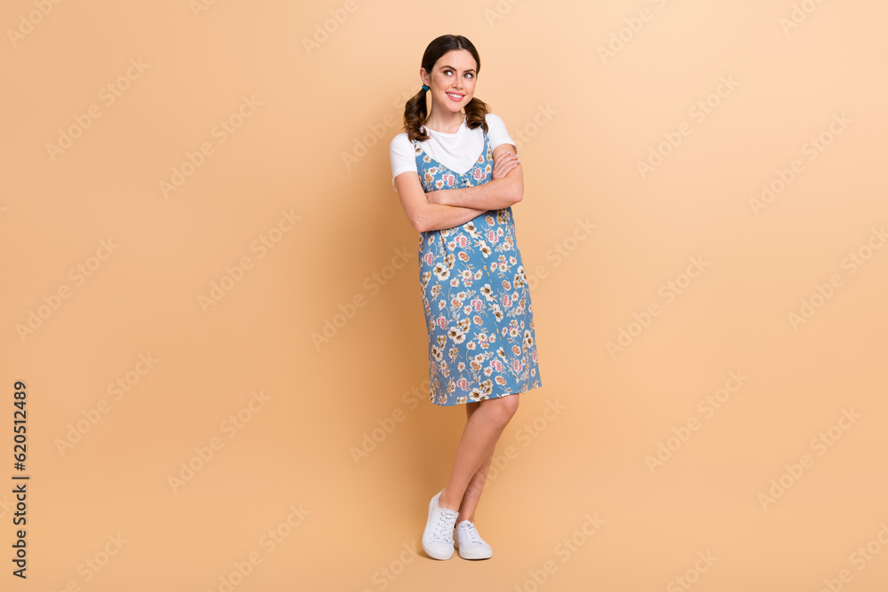 Full body cadre of young thoughtful cute lady wear trendy clothes folded arms look empty space planning isolated on beige color background Full body cadre of young thoughtful cute lady wear trendy clothes folded arms look empty space planning isolated on beige color background