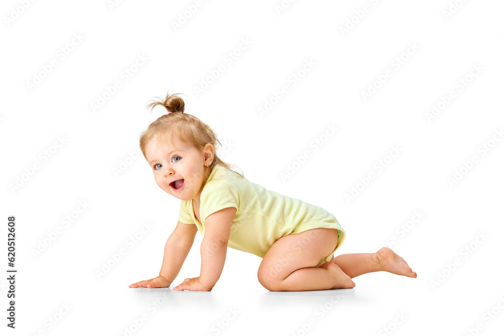 Cheerful, joyful, happy little baby, girl, toddler crawling and laughing against white studio background. Curious child Cheerful, joyful, happy little baby, girl, toddler crawling and laughing against white studio background. Curious child