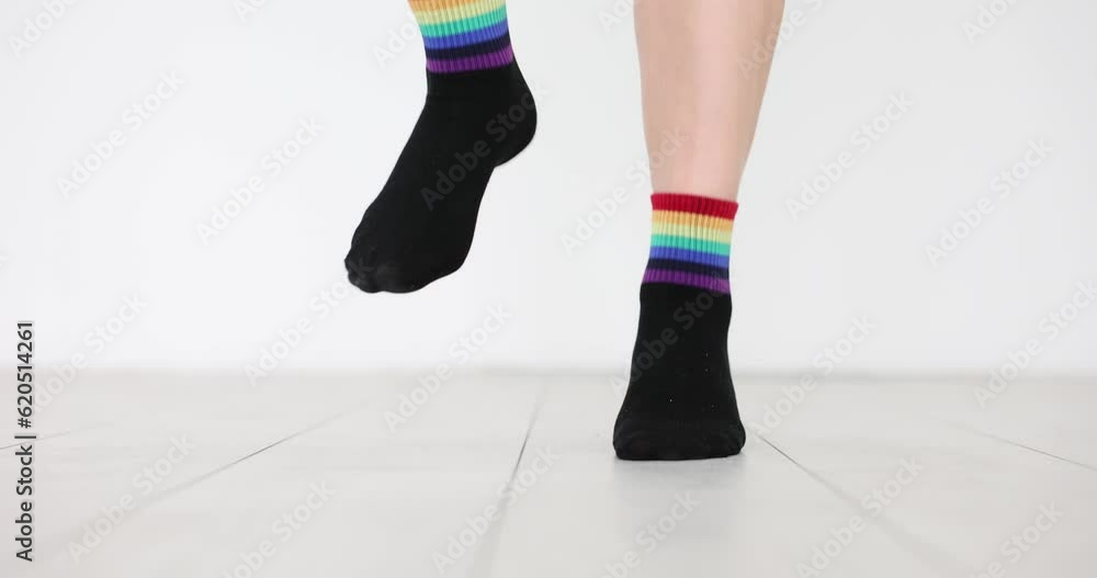 Person in socks with decorated LGBT flag is jumping on floor. Demonstration in support of sexual minorities Person in socks with decorated LGBT flag is jumping on floor. Demonstration in support of sexual minorities