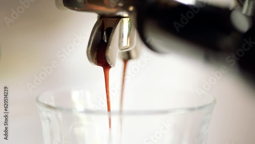 Nahaufnahme von frischem, heißem Kaffee, Espresso, Crema läuft, fließt aus der Espressomaschine. Die selektive Schärfe liegt auf dem laufenden Kaffee photo