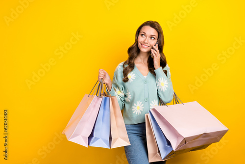 Photo of young influencer fashionista blogger lady call smartphone commerce proposition look empty space bargains isolated on yellow color background