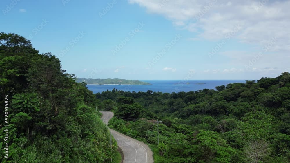 Aerial - Low-rising drone of motorcycle travel down road near beautiful coast Aerial - Low-rising drone of motorcycle travel down road near beautiful coast