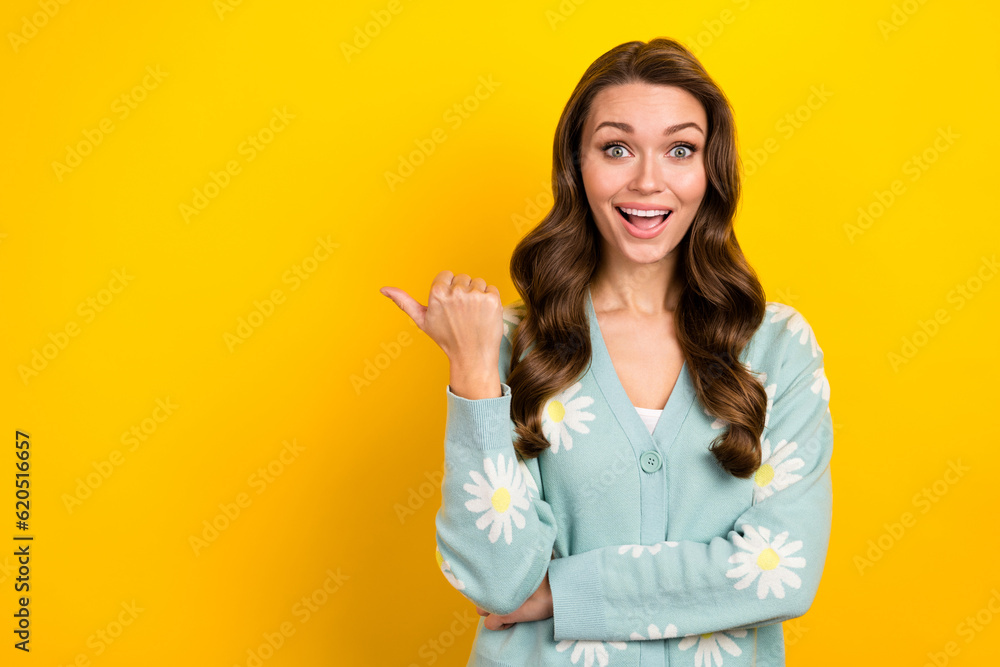 Photo of pretty impressed lady dressed teal cardigan open mouth showing thumb emtpy space isolated yellow color background Photo of pretty impressed lady dressed teal cardigan open mouth showing thumb emtpy space isolated yellow color background