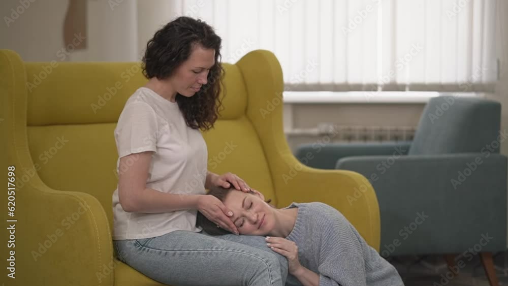 woman ironing her hair. Two women. one woman strokes another on the head through the hair. appointment with a psychologist. High quality Full HD video recording woman ironing her hair. Two women. one woman strokes another on the head through the hair. appointment with a psychologist. High quality Full HD video recording