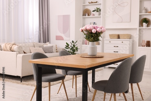 Stylish dining room with cosy furniture and flowers © New Africa
