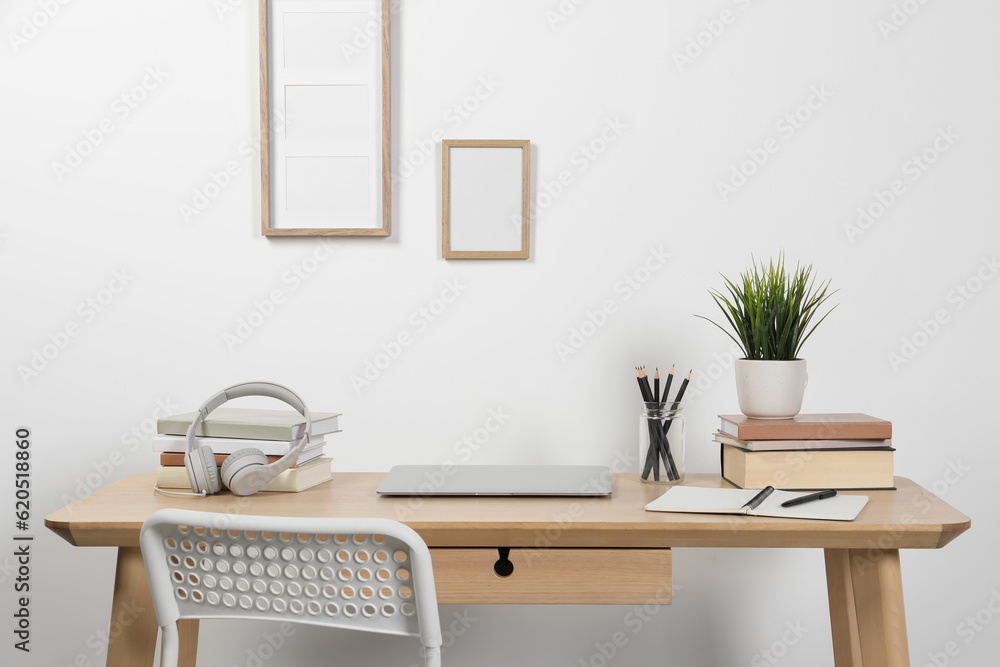 Fototapeta premium Cozy workspace with laptop and stationery on wooden desk at home