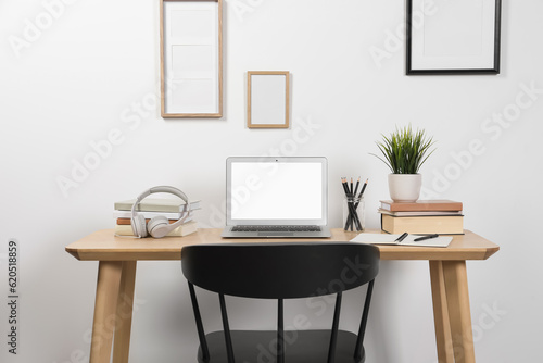 Cozy workspace with laptop and stationery on wooden desk at home © New Africa